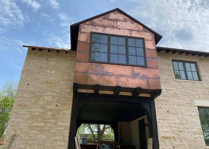 Copper metal panel facade on a stone building for Skylight Installation in Watford City